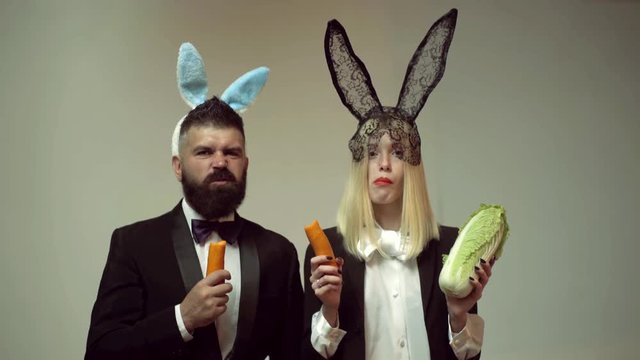 Funny easter bunny. Happy funny easter couple with carrot. Family celebrate Easter. Easter rabbits. Couple with bunny ears.