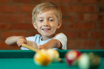 5-6 years old boy playing billiard