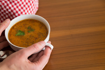 the Tarhana soup in the bowl that the woman hold it for kitchen and food concept. 