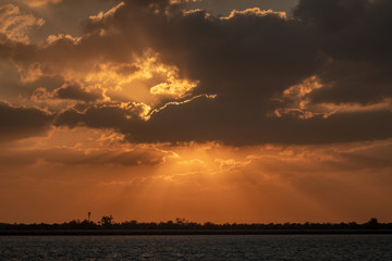 Dramaitc sunset and sunrays peaking through clouds