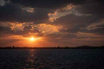 Dramaitc sunset and sunrays peaking through clouds