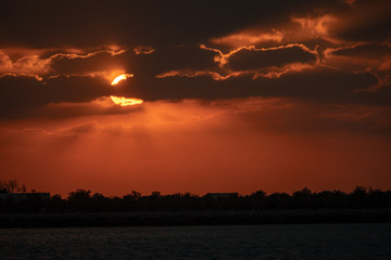 Fototapeta premium Dramaitc sunset and sunrays peaking through clouds