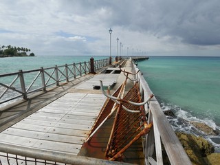 Wooden jetty with broken and rusty planks