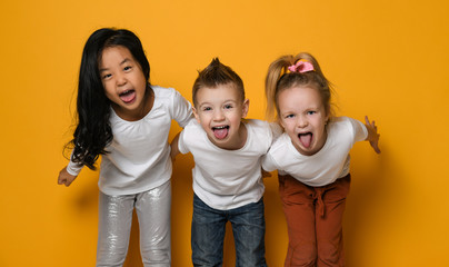 group of funny children of different races show their tongue to the camera.