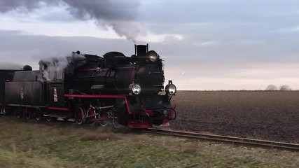Old passangers train running on the tracks. Retro locomotive with steam engine loopable footage.