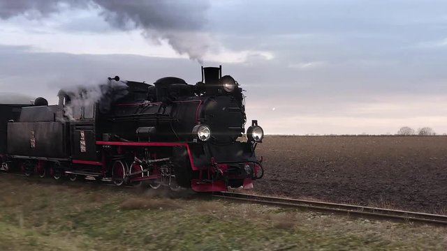 Old passangers train running on the tracks. Retro locomotive with steam engine loopable footage.