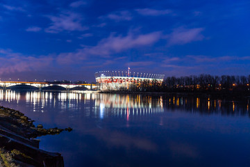 WARSAW, POLAND - FEBRUARY 14, 2019: National Stadium in Warsaw. Night and water reflections in ...