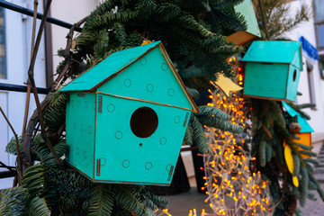 Wooden green bird feeders on the tree. Eco (natural) house.