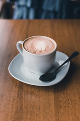 Cup of cappuccino coffee on wooden table