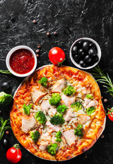Pizza with Mozzarella cheese, salmon fish, broccoli, tomato sauce. Italian pizza on dark background