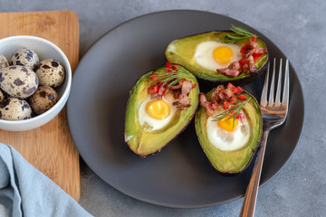 Quail eggs baked in avocado with bacon, red paprika and dill.