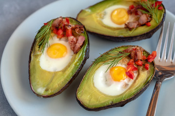Quail eggs baked in avocado with bacon, red paprika and dill.