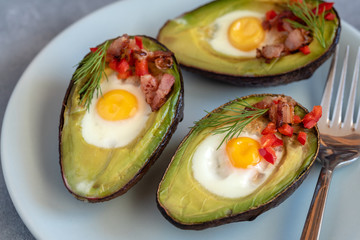 Quail eggs baked in avocado with bacon, red paprika and dill.