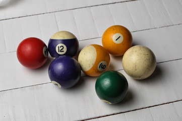 Old billiard balls on white wooden table background