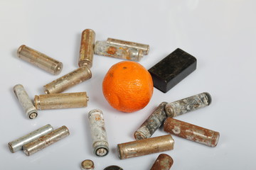 Spent batteries and faded mandarin. Recycling waste batteries. Environmental Protection. Earth Day.