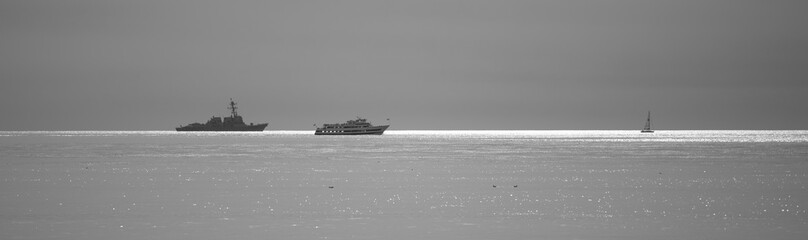 Massive Naval Ships chasing a small sailboat off of point loma