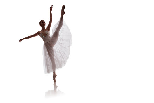 woman ballerina in white long skirt posing on white background photo made in the style of "low key"