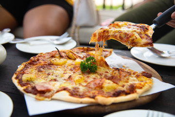 slice of hot pizza with melting on wood plate