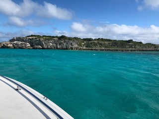 Wide view of the Thunderball grotto, a popular filming location in the Exuma Cays, with the side of a boat in the picture.