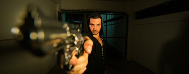 Stick up, a robber pointing his gun to camera