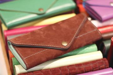 Multicolored leather wallets and covers on the counter in the store