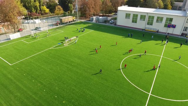 Kids playing football on the stadium