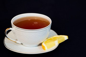 A mug of tea with lemon and chocolate.