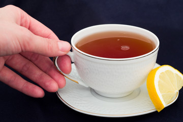 A mug of tea with lemon and chocolate.