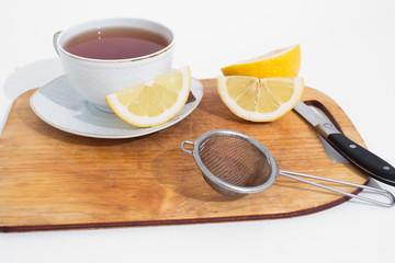 A mug of tea with lemon and chocolate.