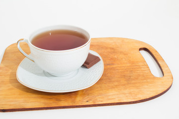 A mug of tea with lemon and chocolate.