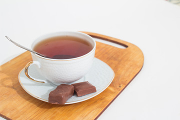 A mug of tea with lemon and chocolate.