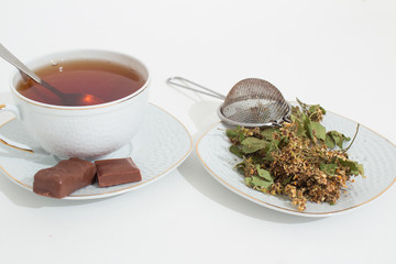 A mug of tea with lemon and chocolate.