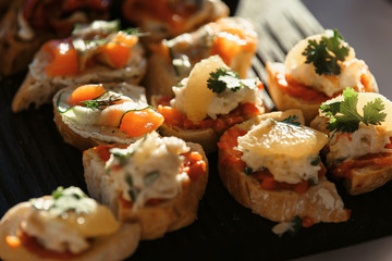 Food snack tray holiday buffet table served by different canape, sandwiches, snacks, nuts, peanuts ready for eating in restaurant