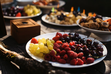 Food fruits and berries snack tray holiday buffet table served by different canape, sandwiches, snacks, nuts, peanuts ready for eating in restaurant