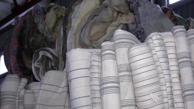 Sorting solid waste. Pressed bale. Recycling textile raw materials. Old, dirty, striped mattresses.
