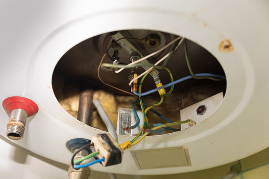 Inside Of The Broken Water Heater Or Boiler With Electric Wires And Pipes For Installation Of The Hoses With Rust And Burn Selective Focus Close Up