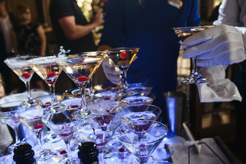 Champagne slide. Pyramid or fountain made of champagne glasses with cherry and steam from dry ice