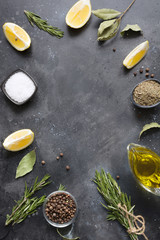 Border with lemon, herbs, spices for fish marinade on vintage grey. Cooking concept.