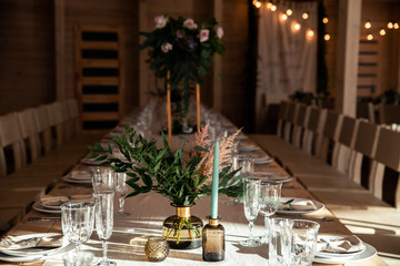 Big green branches on vase on the festive table