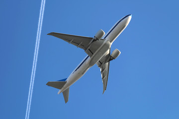 Flugzeug nach dem Start und Kondensstreifen und blauer Himmel - Stockfoto