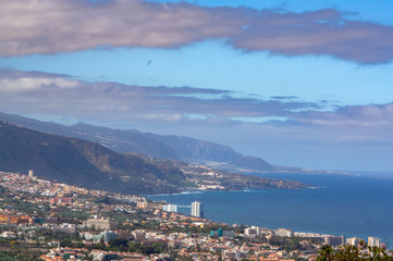 Fototapeta na wymiar far view from a mountain on wild coast with City