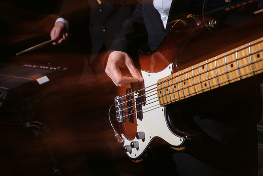 Man playing guitar on a musical concert or in a studio. Close-up view. Dynamic shot in motion slow shutter speed and flash, long exposure