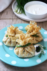 Bags of pancakes stuffed with herring, served with caviar, sour cream and dill on a wooden background. Rustic style.