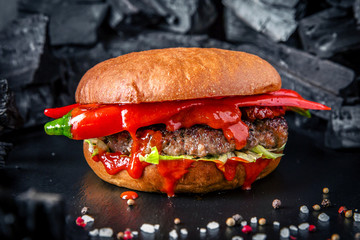 Juicy fresh delicious hamburger with beef and chili sauce. The burger menu.