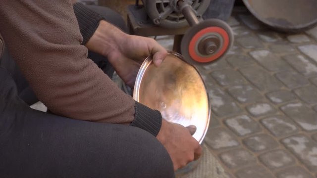 Forming a traditional cooper dish with an emery on the craftsman market. Fes, Morocco, North Africa