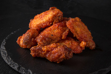 Spicy Wings on black background. Snack to beer. Fast food.