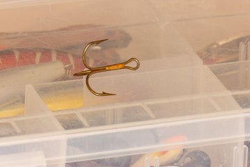 fishing treble hook lying on fishing tackle box