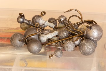 Assorted jig head fishing hooks lying on fishing tackle box