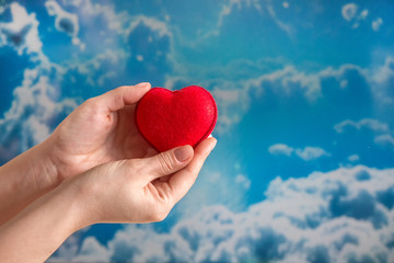 Fototapeta premium hands pass the heart of the child to the day of the donor against the sky, hope for health, for organ donation,blood donor day