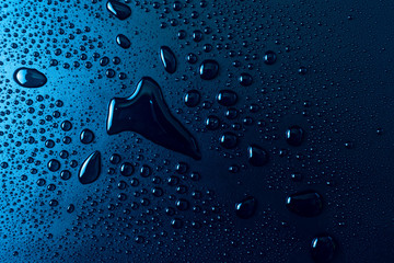Drops of water on a blue glass texture background